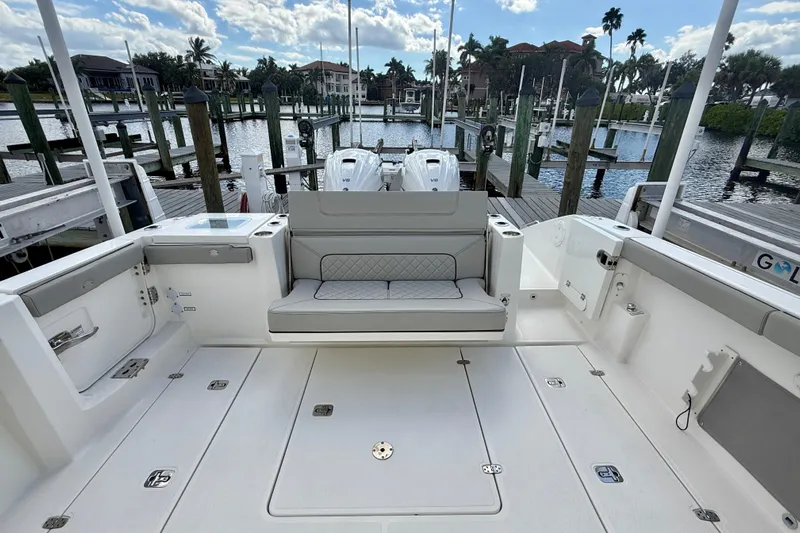  Yacht Photos Pics 2023 Pursuit S 358 Sport boat interior with seating and dock view.