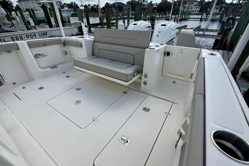  Yacht Photos Pics 2023 Pursuit S 358 Sport boat interior with seating and storage, docked at marina.