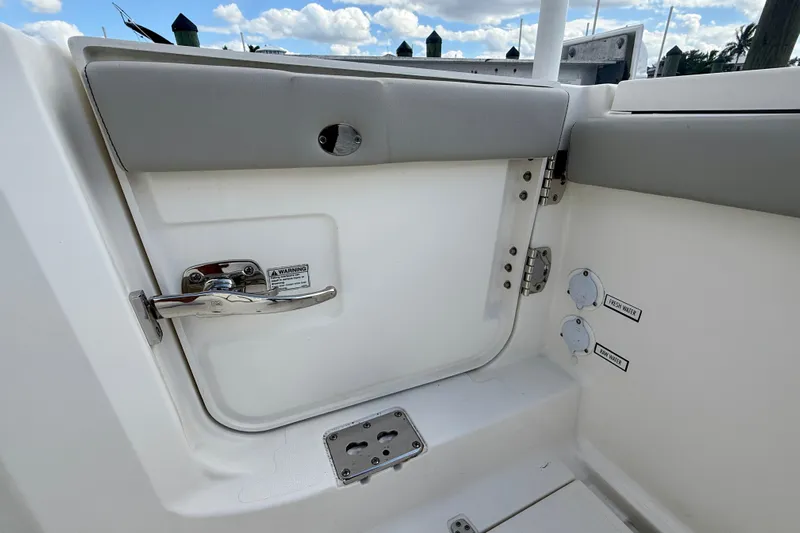  Yacht Photos Pics 2023 Pursuit S 358 Sport boat interior, featuring a door with handle and water access points.