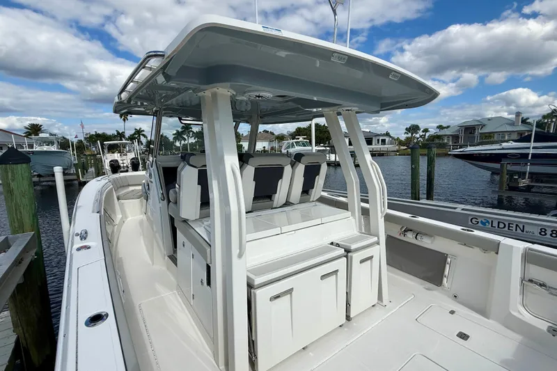  Yacht Photos Pics 2023 Pursuit S 358 Sport boat docked, featuring sleek design and spacious seating.