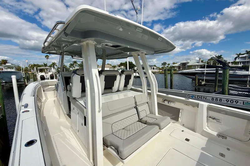 Yacht Photos Pics 2023 Pursuit S 358 Sport boat docked, featuring sleek design and spacious seating.