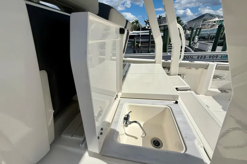  Yacht Photos Pics 2023 Pursuit S 358 Sport boat interior with sink and storage compartments.