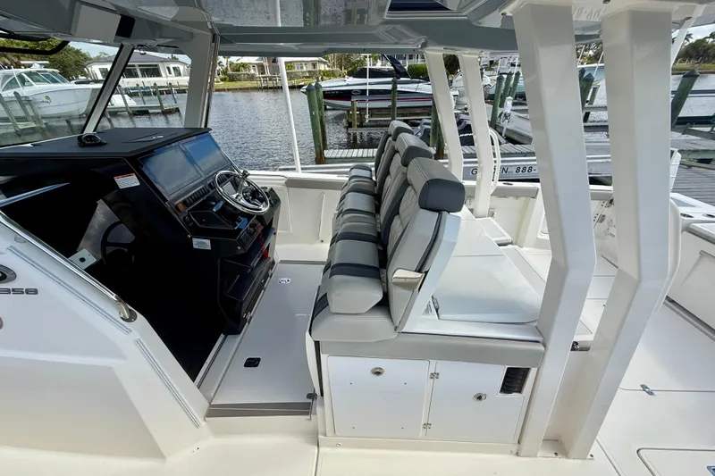  Yacht Photos Pics 2023 Pursuit S 358 Sport boat interior with helm and seating, docked by the water.