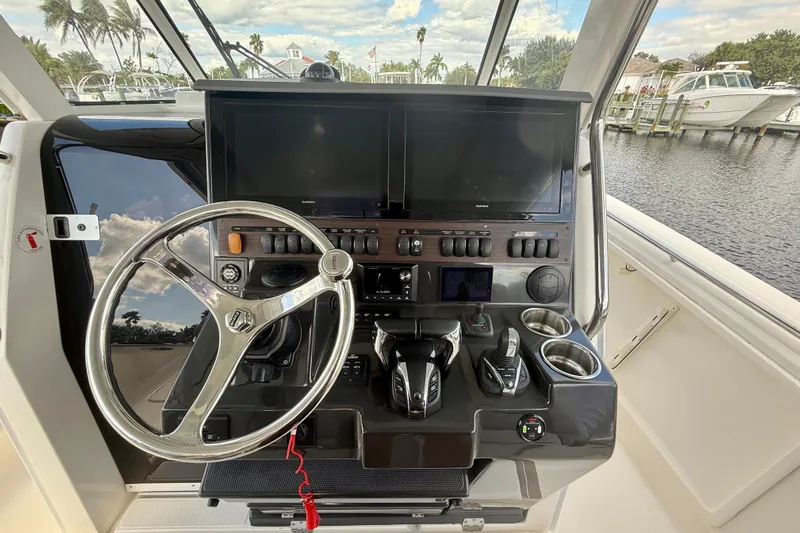  Yacht Photos Pics 2023 Pursuit S 358 Sport boat helm with steering wheel and control panel.