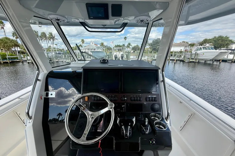 Yacht Photos Pics 2023 Pursuit S 358 Sport boat helm with modern controls and scenic marina view.