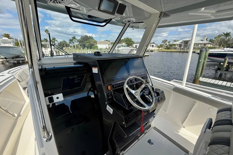  Yacht Photos Pics 2023 Pursuit S 358 Sport boat helm with modern controls and waterfront view.