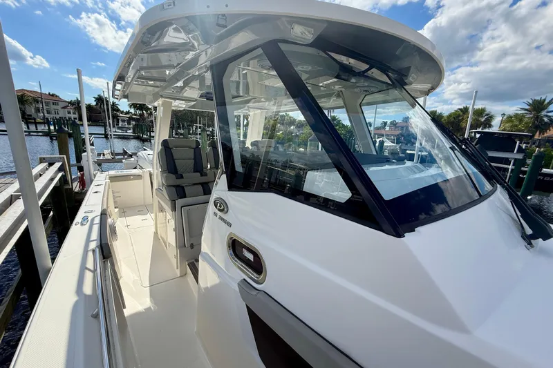  Yacht Photos Pics 2023 Pursuit S 358 Sport boat docked, showcasing sleek design and spacious seating.