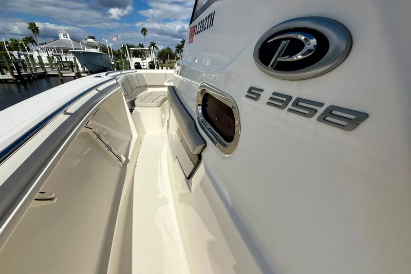  Yacht Photos Pics 2023 Pursuit S 358 Sport boat docked, showcasing sleek design and branding.