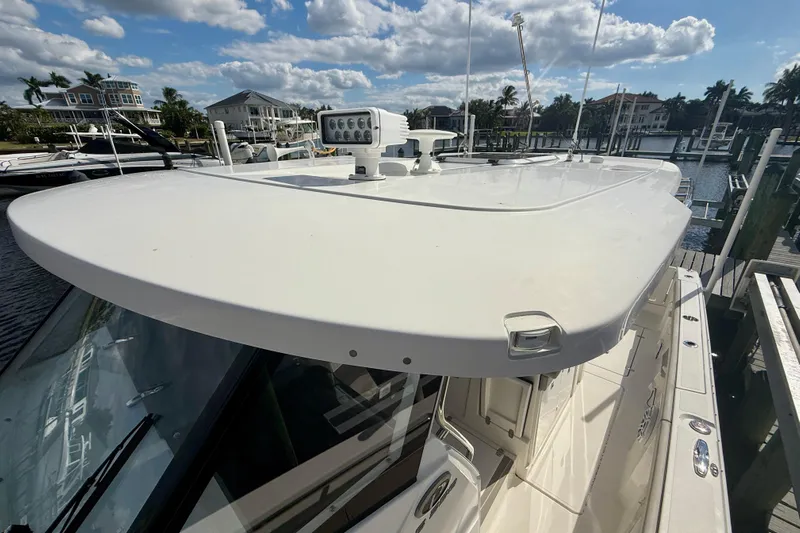  Yacht Photos Pics 2023 Pursuit S 358 Sport boat docked under a partly cloudy sky.