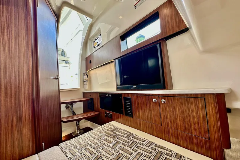  Yacht Photos Pics Luxurious interior of 2023 Pursuit S 358 Sport boat with wood finishes and modern amenities.
