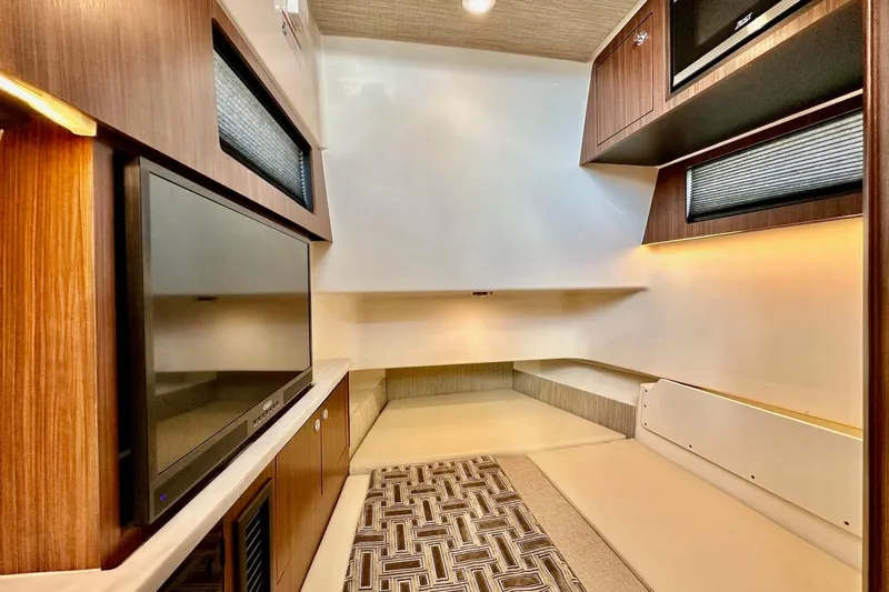  Yacht Photos Pics 2023 Pursuit S 358 Sport interior with modern wood finishes and built-in TV.