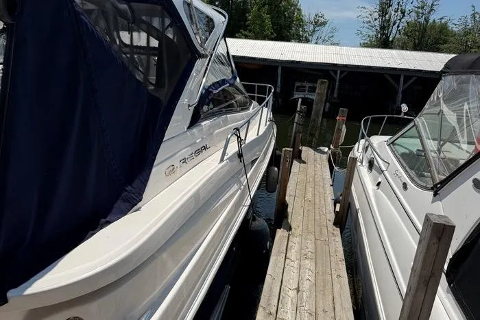 Knot On Call Yacht Photos Pics 2007 Regal Commodore 4060 docked alongside another boat, with a wooden pier in between.