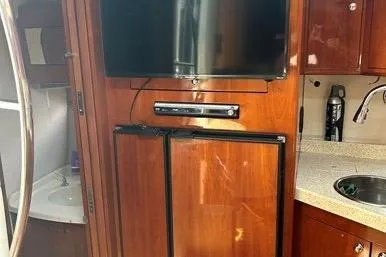 Knot On Call Yacht Photos Pics 2007 Regal Commodore 4060 yacht interior with TV, fridge, and kitchenette.