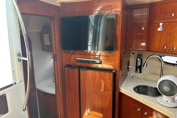 Knot On Call Yacht Photos Pics 2007 Regal Commodore 4060 yacht interior with TV, kitchenette, and bathroom.