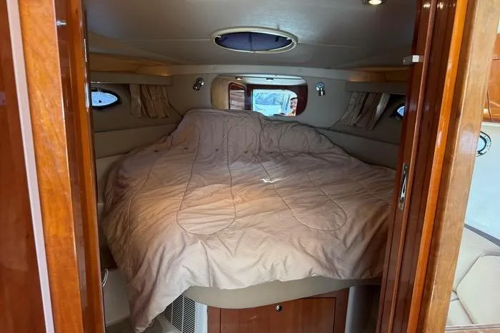 Knot On Call Yacht Photos Pics Interior cabin of 2007 Regal Commodore 4060 yacht with cozy bed and wooden finish.