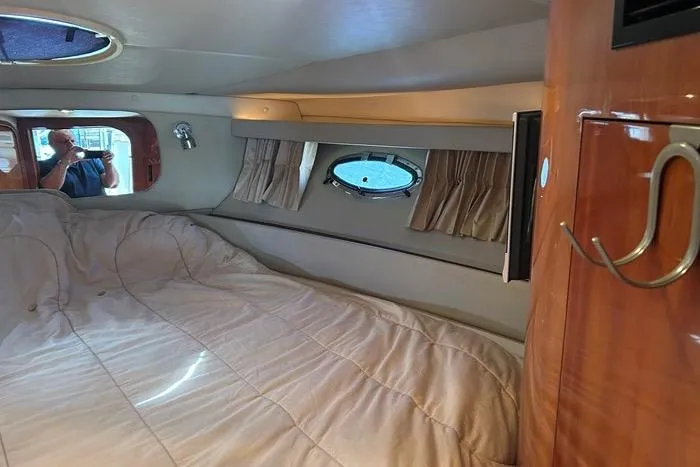 Knot On Call Yacht Photos Pics Cozy cabin interior of 2007 Regal Commodore 4060 yacht with bed and porthole window.