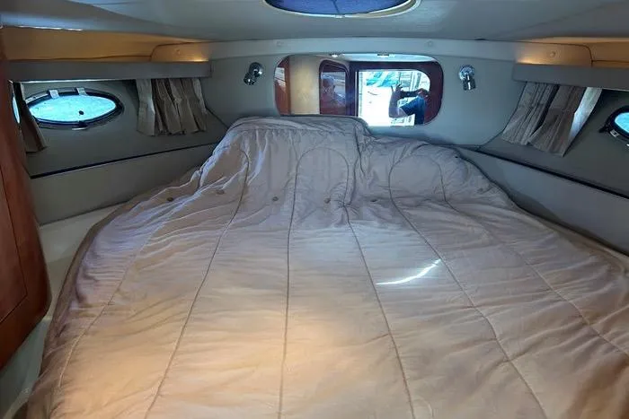 Knot On Call Yacht Photos Pics Interior cabin of 2007 Regal Commodore 4060 yacht with cozy bed and porthole windows.