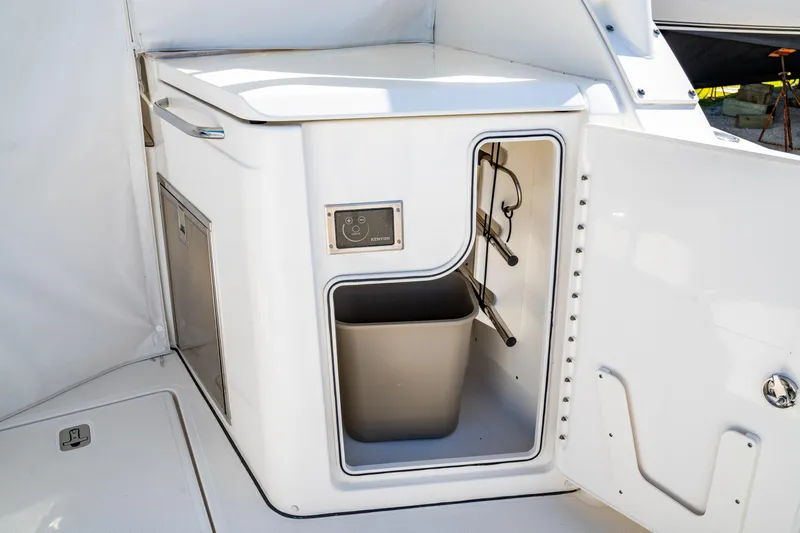 Miss Morgan III Yacht Photos Pics 2021 Pursuit 365DC boat interior with storage compartment and trash bin.