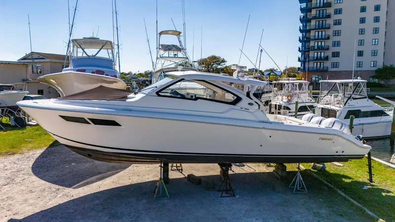 Miss Morgan III Yacht Photos Pics 2021 Pursuit 365DC boat on stands in marina, surrounded by other vessels.