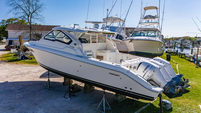 Miss Morgan III Yacht Photos Pics 2021 Pursuit 365DC boat on stands, marina background, clear sky.