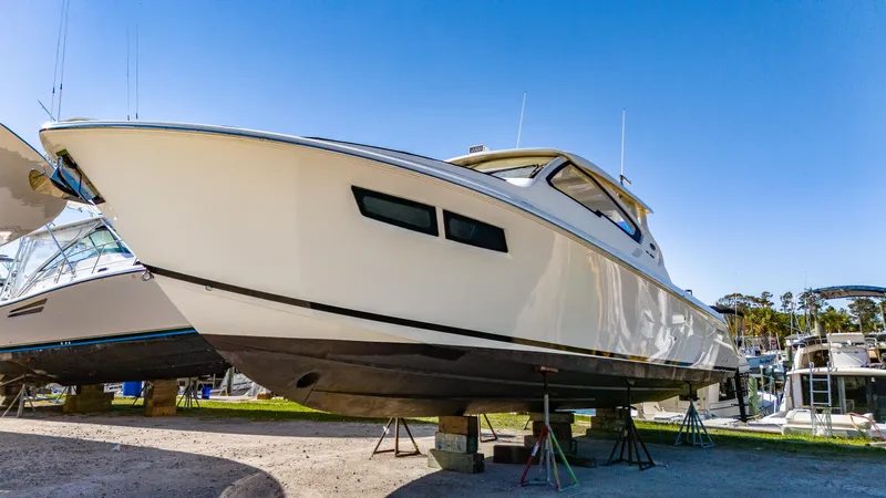 Miss Morgan III Yacht Photos Pics 2021 Pursuit 365DC boat on stands, displayed outdoors under clear blue sky.