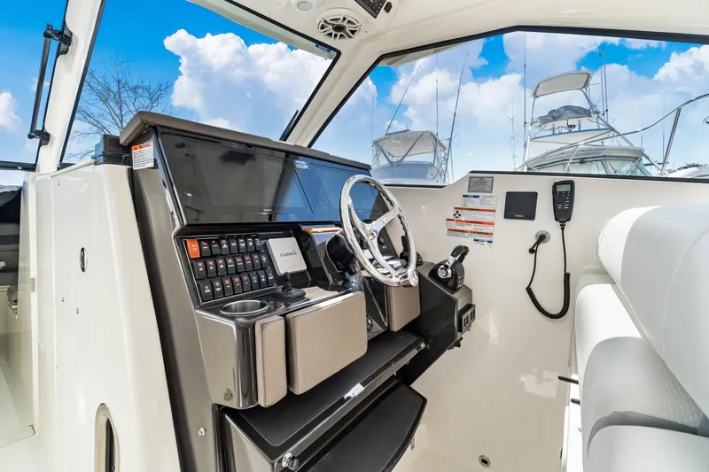 Miss Morgan III Yacht Photos Pics 2021 Pursuit 365DC boat helm with modern controls and steering wheel, under a clear blue sky.