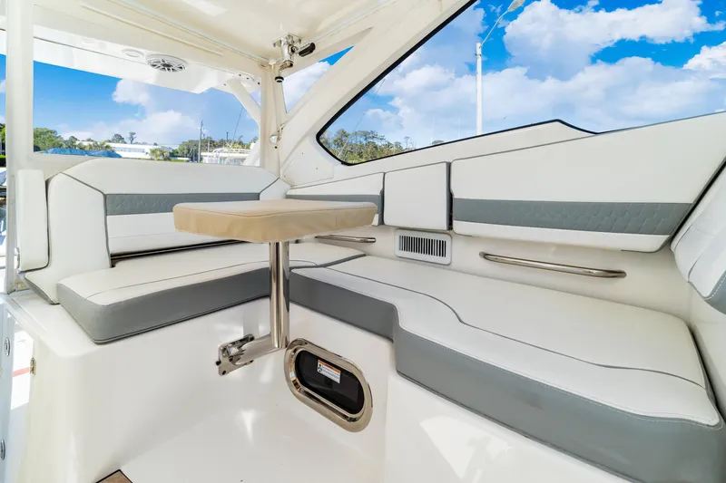 Miss Morgan III Yacht Photos Pics 2021 Pursuit 365DC boat interior with white seating and table under blue sky.