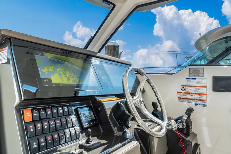 Miss Morgan III Yacht Photos Pics 2021 Pursuit 365DC boat helm with navigation system and steering wheel under blue sky.