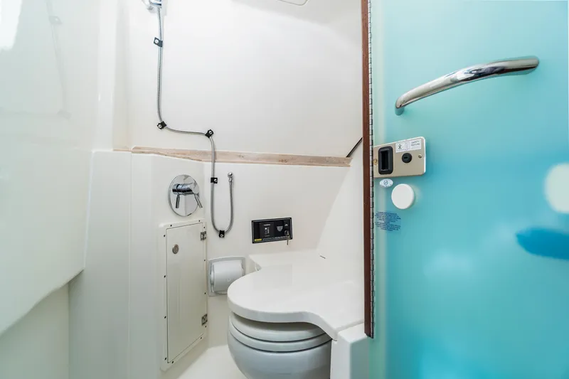 Miss Morgan III Yacht Photos Pics 2021 Pursuit 365DC boat bathroom with modern fixtures and blue door.