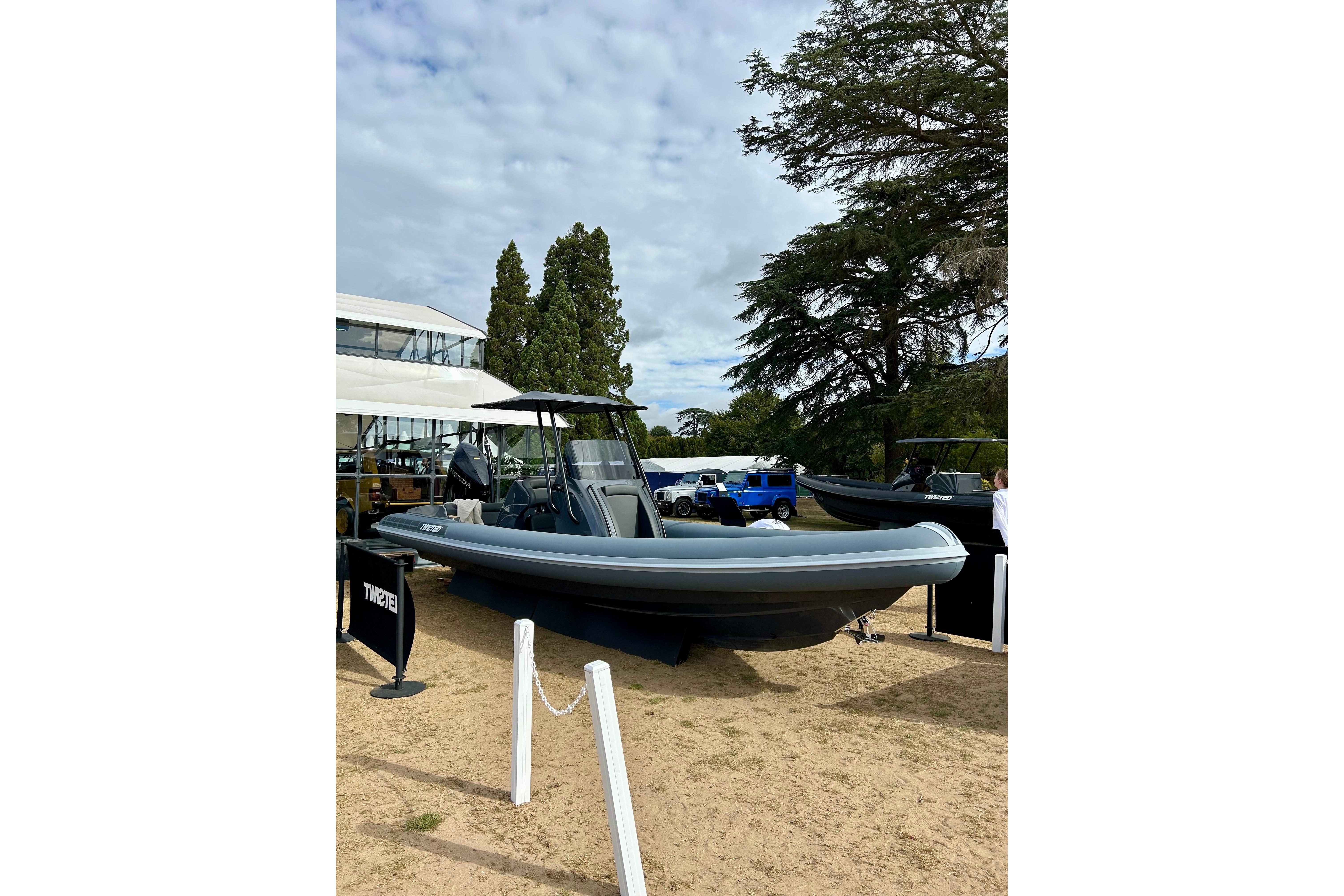 2025 Twisted 28 Sport boat displayed outdoors with trees and sky background.