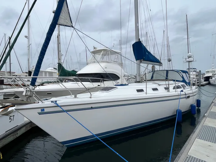 Moonshadow Yacht Photos Pics 1998 Catalina 42 MkII sailboat docked at marina, featuring blue accents and overcast sky.