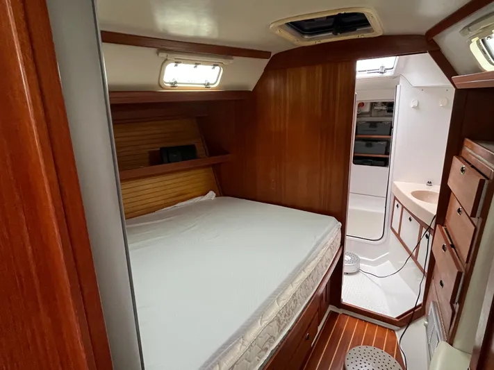 Moonshadow Yacht Photos Pics Cozy cabin interior of 1998 Catalina 42 MkII sailboat with wooden furnishings and bed.