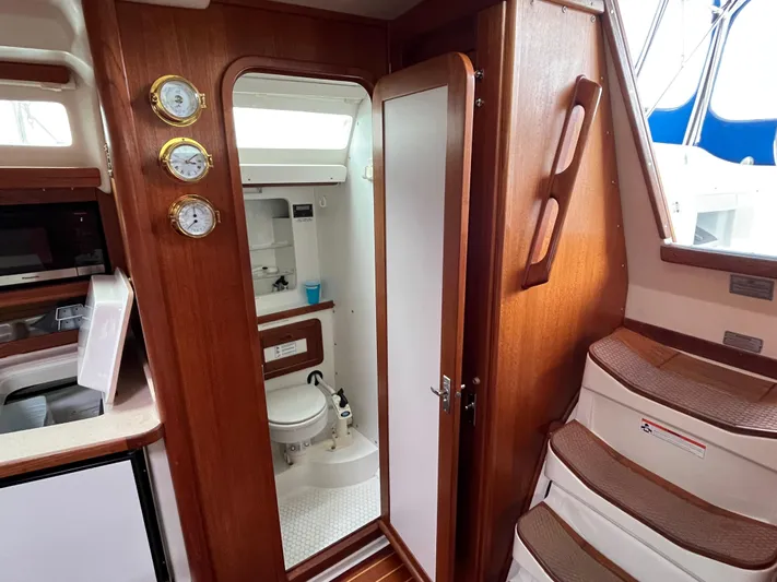 Moonshadow Yacht Photos Pics Interior of 1998 Catalina 42 MkII sailboat, featuring wooden cabinetry and compact bathroom.