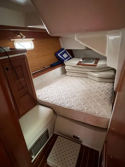 Moonshadow Yacht Photos Pics 1998 Catalina 42 MkII cabin interior with bed, wooden accents, and porthole window.