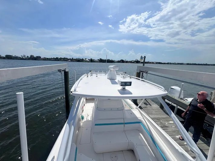  Yacht Photos Pics 2017 Intrepid 327 Cuddy boat docked by the water under a clear blue sky.