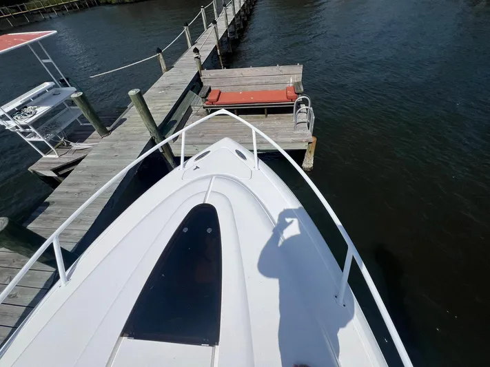  Yacht Photos Pics Bow view of 2017 Intrepid 327 Cuddy docked at a wooden pier.
