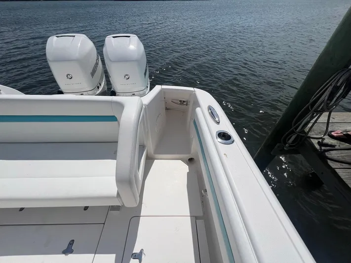  Yacht Photos Pics 2017 Intrepid 327 Cuddy boat with twin Mercury engines docked by the water.
