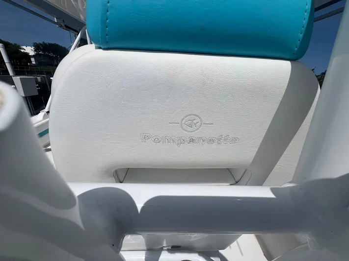  Yacht Photos Pics 2017 Intrepid 327 Cuddy boat seat with Pompanette logo, featuring white and blue upholstery.