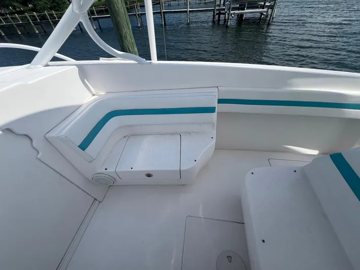  Yacht Photos Pics 2017 Intrepid 327 Cuddy boat interior with white and teal seating, dockside view.
