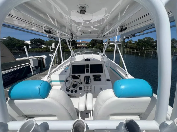  Yacht Photos Pics 2017 Intrepid 327 Cuddy boat cockpit with blue and white seating, docked by the water.