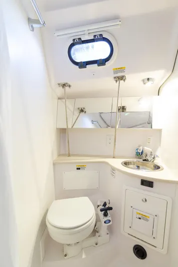 Nordlys Yacht Photos Pics 2018 Catalina 315 yacht bathroom with toilet, sink, and porthole window.