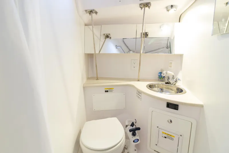 Nordlys Yacht Photos Pics Compact bathroom in 2018 Catalina 315 yacht with toilet, sink, and mirror.
