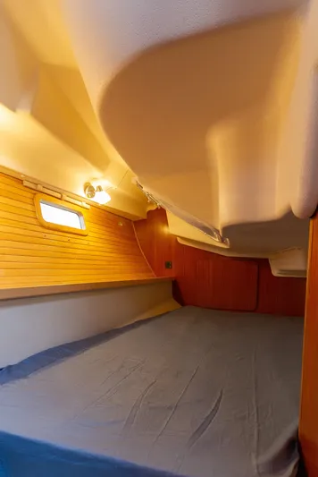 Nordlys Yacht Photos Pics 2018 Catalina 315 yacht interior cabin with wooden paneling and cozy bedding.