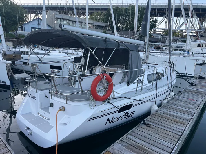 Nordlys Yacht Photos Pics 2018 Catalina 315 sailboat docked in marina, featuring a covered cockpit and life preserver.
