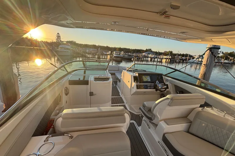  Yacht Photos Pics 2022 Searay SLX350 boat interior at sunset, docked in a serene marina.