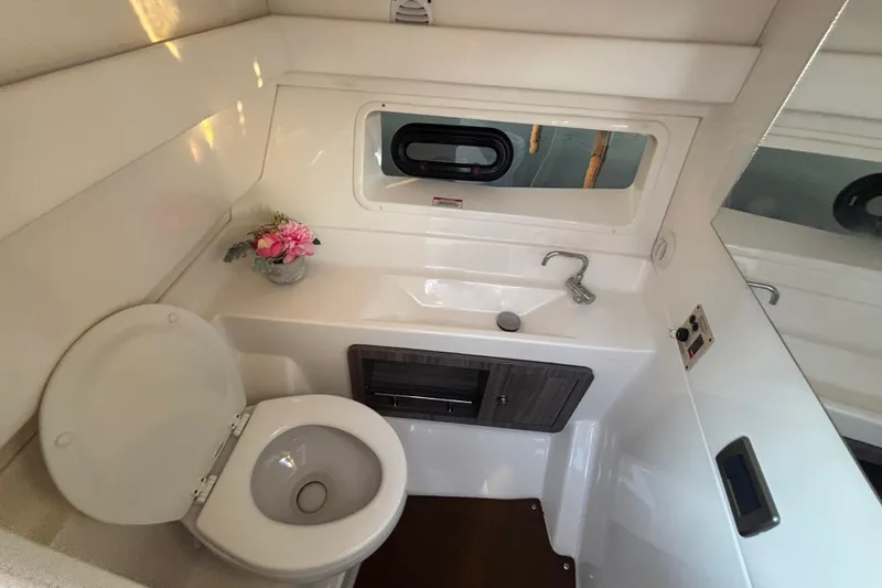  Yacht Photos Pics 2022 Searay SLX350 boat bathroom with toilet, sink, and window.