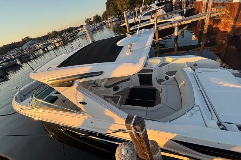  Yacht Photos Pics 2022 Searay SLX350 boat docked at marina during sunset, showcasing luxurious seating and sleek design.