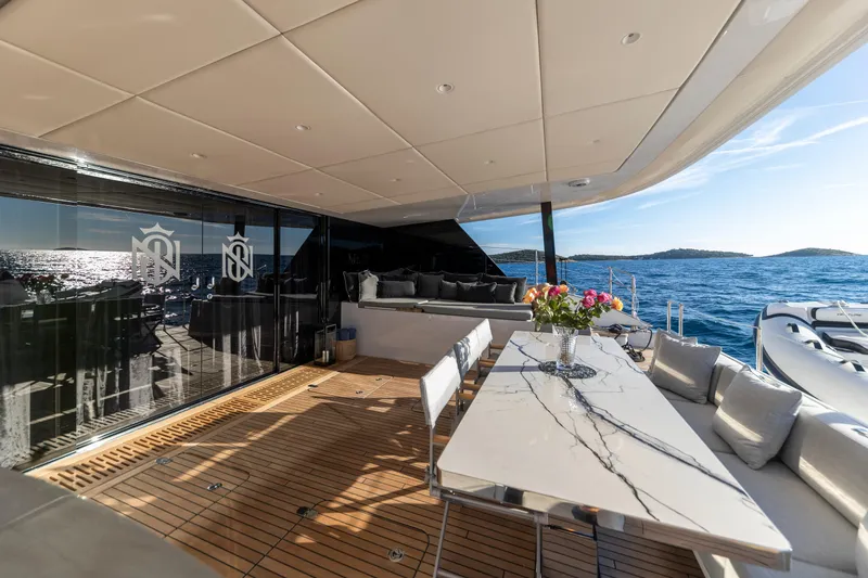 Mr. Si Yacht Photos Pics Luxurious Sunreef 60 Sail yacht deck with elegant dining area, ocean view, 2023 model.