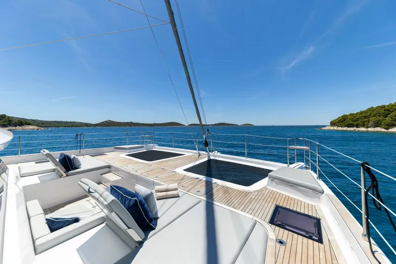 Mr. Si Yacht Photos Pics Luxurious Sunreef 60 Sail yacht deck with sun loungers, ocean view, 2023 model.