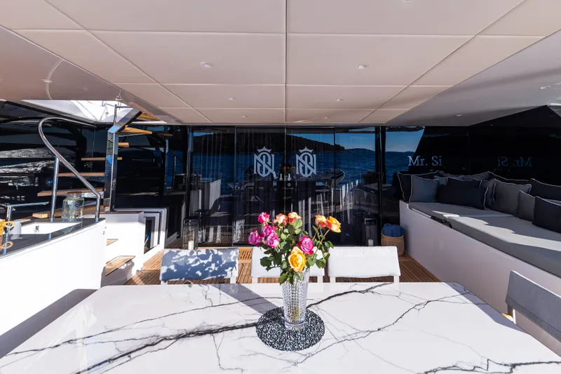 Mr. Si Yacht Photos Pics Luxurious Sunreef 60 Sail yacht interior with marble table and vibrant flower arrangement, 2023 model.